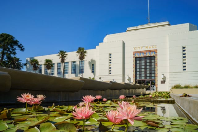 Santa Monica City Hall with blooming water lilies in the foreground under a clear blue sky.