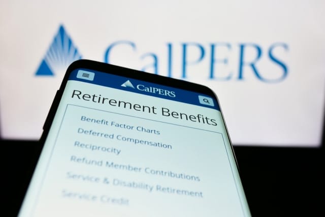 Smartphone screen showing CalPERS retirement benefits page in front of CalPERS logo on a monitor.